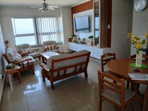 a living room with a table and chairs and a dining room at Oceanview Holiday Apartments in Amanzimtoti