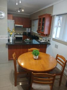 a kitchen with a wooden table with a potted plant on it at Oceanview Holiday Apartments in Amanzimtoti