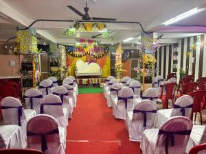 a banquet hall with rows of chairs and a stage at Sadyal Hotel And Restaurant in Tīra Sujānpur