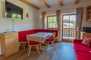 a living room with a red couch and a table at Untergisserhof in Sesto