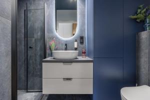 un bagno con lavandino e specchio di Emihouse Rubikon Apartments a Rzeszów
