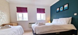 a bedroom with two beds and two windows at The Belmont, Old Town in Swindon