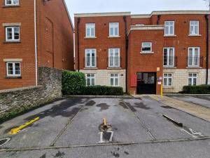 an empty parking lot in front of a brick building at The Belmont, Old Town in Swindon