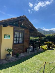 a small building with a bench in a yard at Pousada Luar da Serra Lumiar in Nova Friburgo