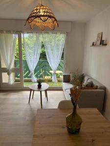 a living room with a couch and a table at Le Belvédère - Balcon plein sud au calme in Saint-Pierre-du-Mont