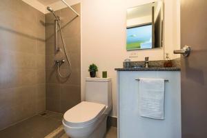 Un baño con inodoro, lavabo y ducha. en Studio Panorámico en la Ciudad, en Curridabat