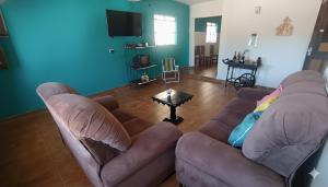 a living room with a couch and a table at Casa Gaita - Temporada in Triunfo
