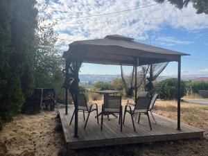 a table and chairs under an umbrella on a wooden deck at Hilltop Orchard Guest Suite with Scenic View in Yakima