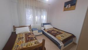 two beds sitting in a room with at Golem Green Retreat in Golem