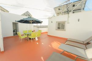 a patio with a table and chairs and an umbrella at Casa Pepi Sánchez Conil in Conil de la Frontera
