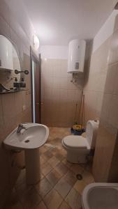 a bathroom with a white toilet and a sink at Golem Green Retreat in Golem +15 photos