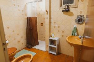 a bathroom with a shower and two toilets and a sink at IKE Hospedagem Uruguaiana - CENTRO in Uruguaiana +31 photos
