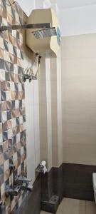 a bathroom with a toilet paper dispenser on the wall at Hotel Darshan Inn in Prayagraj