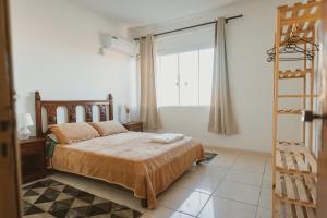 a bedroom with a bed and a window and a ladder at IKE Hospedagem Uruguaiana - CENTRO in Uruguaiana