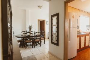 a kitchen and dining room with a table and a refrigerator at IKE Hospedagem Uruguaiana - CENTRO in Uruguaiana