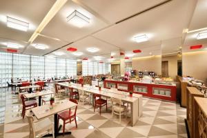 Un restaurante con mesas y sillas y una cafetería. en Genting Hotel Jurong, en Singapur