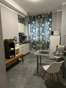 a kitchen with a glass table and a table and chairs at Suite excelsior garden living in Parma