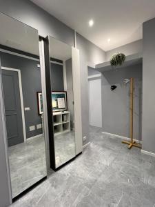 a room with a hallway with two mirrors and a television at Suite excelsior garden living in Parma +7 photos