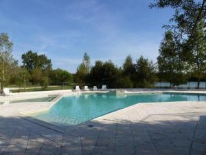 ein Swimmingpool mit blauem Wasser in einem Hof in der Unterkunft La Terrasse du Lac in Sainte-Gemme