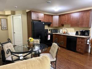 a kitchen with a glass table and a black refrigerator at Home away from home in St. John's