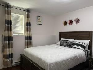 a bedroom with a bed with black and white pillows at Home away from home in St. John's