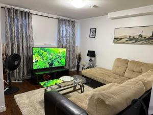 a living room with a couch and a flat screen tv at Home away from home in St. John's
