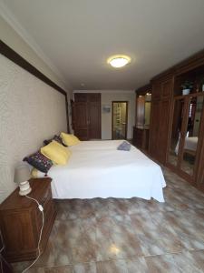 a bedroom with a large white bed with yellow pillows at Casa Adora in Santa Ursula im Norden Teneriffas in Santa Úrsula