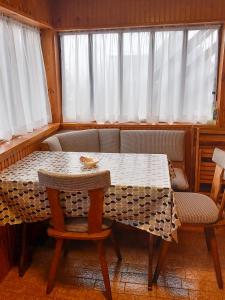 a table and chairs in a room with curtains at Cozy Cabin in Sekulić 