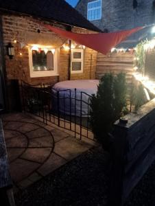 a bed outside of a house at night at Larch Cottage Ruston with hot tub, dogs go free in Scarborough