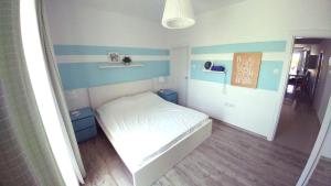 a small bedroom with a white bed and blue stripes at Трехкомнатные апартаменты в жилом комплексе Caesar Beach F14 Flat4 in Boğaz +43 photos