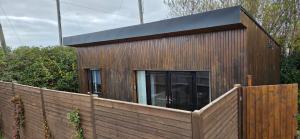 ShanagarryにあるBeach Cabin, Cork, near Ballymaloe House & Garryvoe Hotelsの木塀裏の小屋