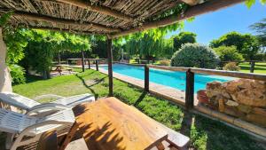 a patio with a table and chairs and a swimming pool at Cabañas Altos de la Bodega in San Rafael