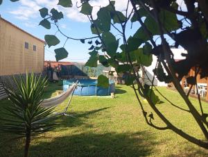 a hammock in a yard with a swimming pool at Dinocamp in Lourinhã