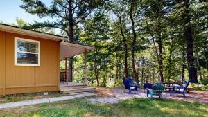 une maison avec des chaises et une table dans la cour dans l'établissement Roseway River Cottages, à Shelburne