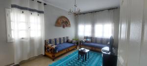 - un salon avec deux canapés bleus et un tapis bleu dans l'établissement Évasion côtière à la Corniche - Villa sur la mer, à Banzart