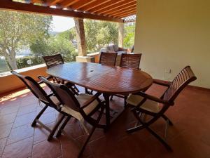une table et des chaises en bois dans un salon dans l'établissement Villetta Sunrise 21, à Costa Rei