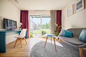 a living room with a couch and a tv at SEEGER Living Premium West in Karlsruhe