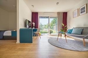a living room with a bed and a couch and a table at SEEGER Living Premium West in Karlsruhe