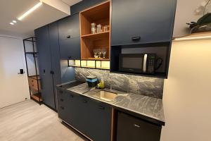 a kitchen with a sink and a microwave at 403 Ocean Art Park - Take Home in Tambaú