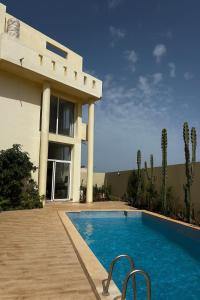 una casa con piscina al lado de un edificio en Ims'Chill Hotel, en Imsouane