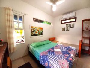 a bedroom with a bed and a window at Floripa Beach House Hostel in Florianópolis