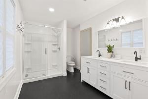 a white bathroom with a shower and a sink at Blue Mountain Song- Massanutten Home with Hot tub! in Hopkins Spring +26 photos