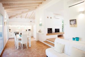 a white living room with a white couch and a table at Tenuta le marze in Castiglione della Pescaia