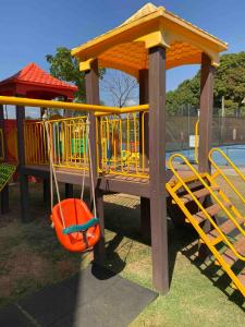 巴西利亚Estiloso Flat Particular no Lake Side的公园里有橙色秋千的游乐场