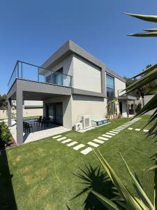 a house with a large yard in front of it at Vip lüks Odalar banyo ve klimalı in Cesme