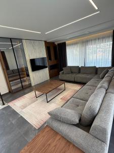 a living room with a large couch and a table at Vip lüks Odalar banyo ve klimalı in Cesme