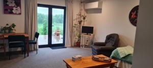 a living room with a couch and a table and a television at Bordeaux Retreat in Te Kauwhata