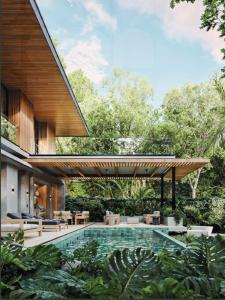 a house with a swimming pool in a garden at Casa Nunc - New Home - 3 Minute Walk to the Beach in Nosara