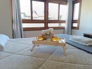 a bedroom with a bed and a table with shoes on it at Apartamento Coração de Gramado in Gramado