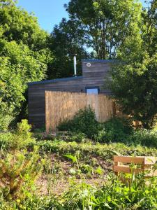 a house with a wooden fence in a garden at Tiny house chaleureuse en Matheysine in Saint-Jean-de-Vaux